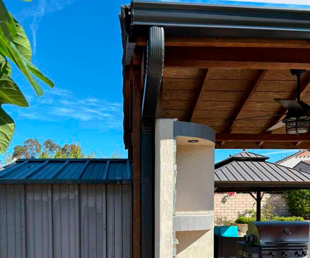 Black K-style gutters and downspouts installed on a wooden chalet by CWB Gutters