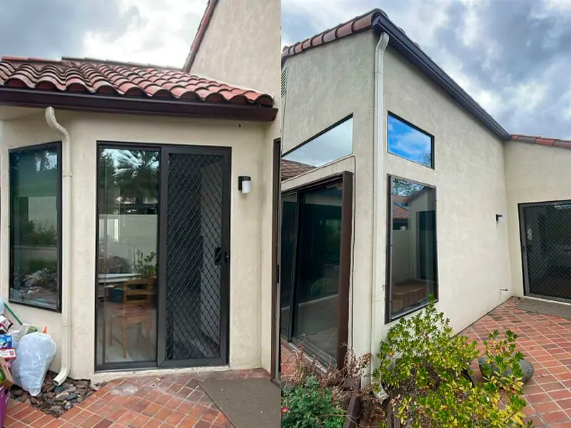 Beige stucco house exterior featuring dark brown gutters and off-white downspouts.